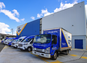 Fleet of Storage King vans all with custom fleet wraps. lined up in front of a large storage king.